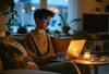 Enjoying blue light glasses benefits while working comfortably in a cozy, candlelit home setting