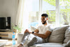 Relaxing at home, this man enjoys wellness benefits with budget smartwatch features for daily balance